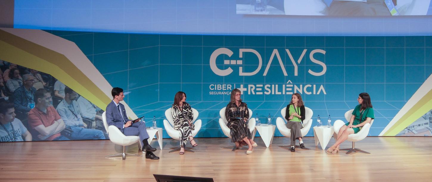 painel de debate em palco na conferência C-DAYS