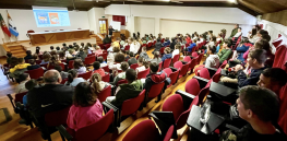 jovens alunos em auditório a ouvir orador 